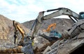 Salvaging and recycling building and construction materials. Excavators work at landfill with concrete demolition waste. Recycling
