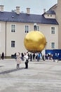 Golden sphere with a man - sculptor Stephan Balkenhol on Kapitelplatz square in Salzburg, Austria