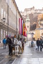 Nostalgic horse driven coach giving visitors a city tour in Salzburg, Austria