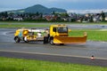 Airport runway cleaning. Airfield concrete and asphalt surface cleaner. Snowplow. Snow and dirt removal tractor vehicle