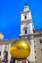 Salzburg, Austria - May 01, 2017: The golden ball statue with a man on the top sculpture, Kapitelplatz Square, Salzburg,