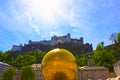 Salzburg, Austria - May 01, 2017: The golden ball statue with a man on the top sculpture, Kapitelplatz Square, Salzburg,