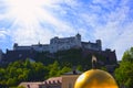 Salzburg, Austria - May 01, 2017: The golden ball statue with a man on the top sculpture, Kapitelplatz Square, Salzburg,