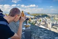 SALZBURG, AUSTRIA - OKTOBER 10, 2018: Young man looks by telescope at old city in Salzburg Austria