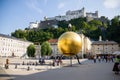 Sphaera Sculpture golden sphere statue with Fortress Hohensalzburg