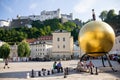 Sphaera Sculpture golden sphere statue with Fortress Hohensalzburg