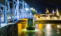 Salzburg night lights from the Salach river with the old iron bridge.