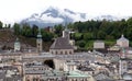 Salzburg old town and high snow alpine mountains at far