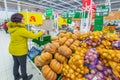 Samara March 2019: A beautiful mature woman weighs vegetables on scales in a large grocery center.