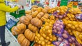 Samara March 2019: A beautiful mature woman weighs vegetables on scales in a large grocery center.