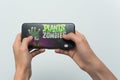 Samara, Russia -07, 29, 2019: A young guy plays a plants vs. zombies game on Iphone 8 Plus. Teenage boy holding a phone in his