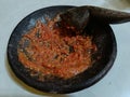 Sambal Terasi is a typical Indonesian chili sauce made using a mortar and pestle isolated on a white background