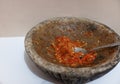 Sambal or traditional chili sauce from Indonesia, freshly made using stone mortar and spoon, Isolated in white background Royalty Free Stock Photo