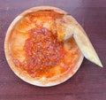 Sambal or traditional chili sauce from Indonesia, freshly made using wooden mortar and pestle. Flat lay or top view Royalty Free Stock Photo