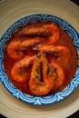 `Sambal Udang` or Spicy Chili prawns in a blue and wooden plate over wooden background. South East Asian cuisine. Royalty Free Stock Photo