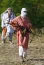Veiled soldier is standing with the Kalashnikov machine gun in their hands