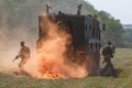 Several Russian special forces fighters disembark from an armored car in the orange screening smoke