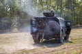 Soldiers of special purpose detachment driving in an armoured car across the field and shooting a machine gun