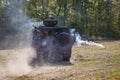 Soldiers of special purpose detachment driving in an armoured car across the field and shooting a machine gun