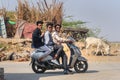 Three indian boys are sitting on motorbike in Sambhar Lake Village. Rajasthan. India