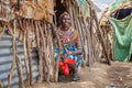 SAMBURU, KENYA - JUNE 25, 2019-Samburu village woman wearing colorful beads indicating her rank while sitting in her hut`s doorwa