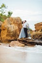 Same couple with a bride in a blue dress walk