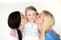 Same sex mothers kissing their daughter