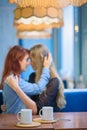 Same-sex relationships. Happy lesbian couple sitting in a cafe. Girls gently hold hands and drink coffee. Embrace of Royalty Free Stock Photo