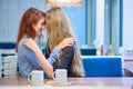 Same-sex relationships. Happy lesbian couple sitting in a cafe. Girls gently hold hands and drink coffee. Embrace of Royalty Free Stock Photo