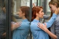 Same-sex relationships. Portrait of two young lesbians stand on the street and kiss. A young woman passionately presses Royalty Free Stock Photo