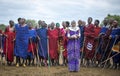 Maasai woman shaking her shoulders in front of men