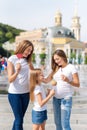 Samesex lesbian family with child on a walk in the park near the fountains. Lesbians mothers with adopted child, happy