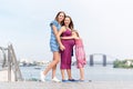 Samesex lesbian family with child on a walk in the park near the river. Lesbians mothers with adopted child, happy