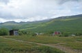 Sami houses in green hills landscape of Abisko National Park. Goahti is Lappish traditional dwelling made from fabric, peat moss Royalty Free Stock Photo