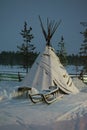 Sami tent and standing next to the sled during the polar night Royalty Free Stock Photo