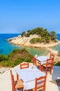 Tables with chairs in typical Greek tavern in Kokkari bay, Samos island, Greece Royalty Free Stock Photo