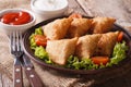Samosa delicious pastry on a plate with tomatoes and lettuce
