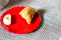 Samosa, peda barfi on red plate and woven mat, typical indian snack breakfast