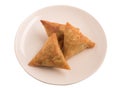 Samosas a spicy blend of vegetables or meat wrapped in a deep fried triangular pastry parcel in a white plate. Royalty Free Stock Photo