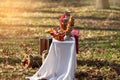 Samovar with bagel on white tablecloth. Side view. Sack on grass in forest