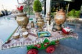 Samovar, tea kettles and teapots on table for refreshments near the shopping mall.