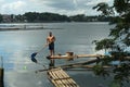 boatman paddle bamboo raft boat across mountain lake.