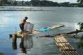 Massive Man launching fish trap snare on lake water