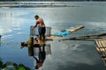 Massive Man launching fish trap snare on lake water