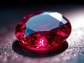 Close-up of a faceted oval-shaped red gemstone on a textured dark surface under studio light. Royalty Free Stock Photo