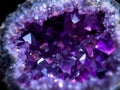 Close-up of a geode with purple amethyst crystals on a dark background, with a soft studio light Royalty Free Stock Photo