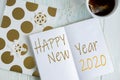 Sample layout of New Year`s greetings with snowflakes, open notebook, cup of tea on a light wooden background. Frame for text. Royalty Free Stock Photo