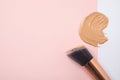 Sample of liquid foundation and makeup brush on color background. Space for text Royalty Free Stock Photo