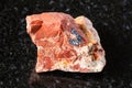 sample of raw red jasper mineral on black granite Royalty Free Stock Photo