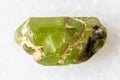 sample of rough peridod crystal on white marble Royalty Free Stock Photo